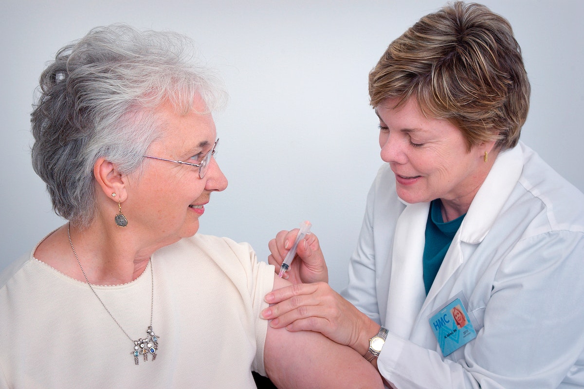 A doctor administering an intramuscular immunization to a middle–aged woman. Original image sourced from US Government department: Public Health Image Library, Centers for Disease Control and Prevention. Under US law this image is copyright free, please credit the government department whenever you can”.