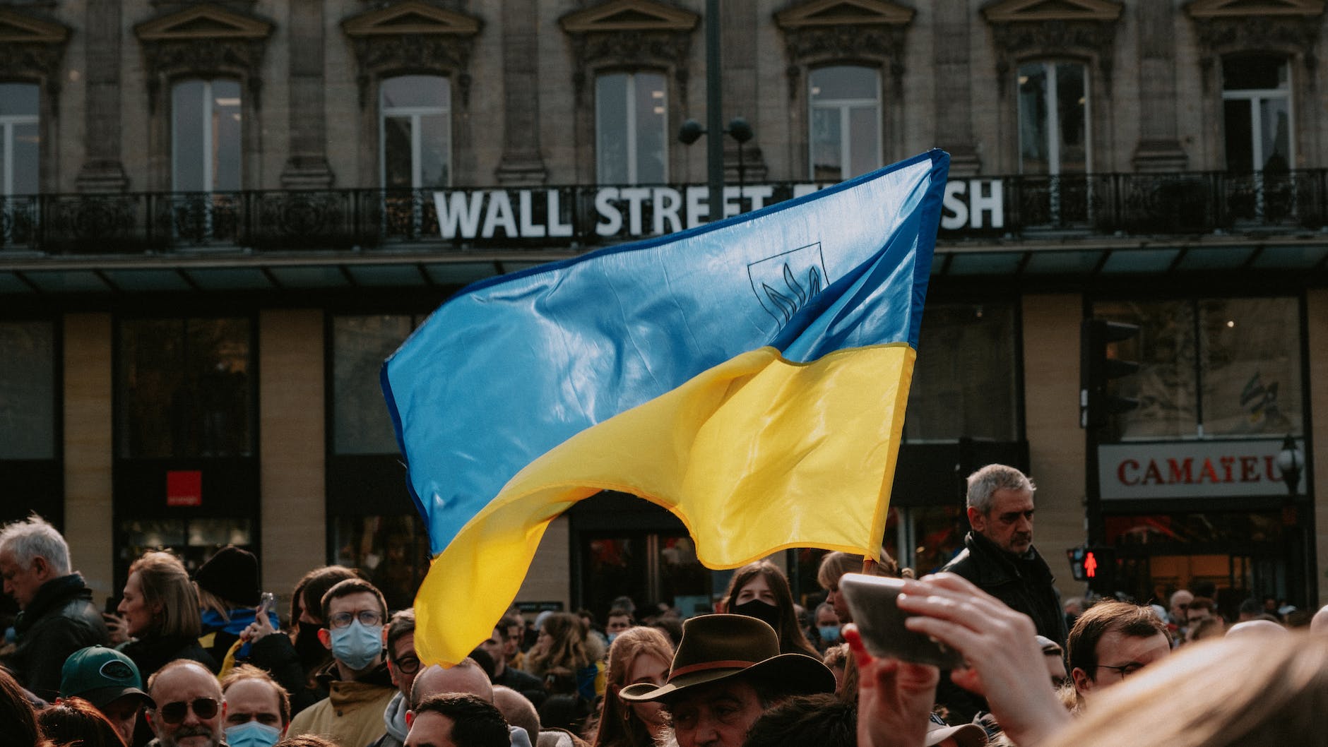 People have discovered Ukraine - blue and yellow ukrainian flag waving above crowd of people