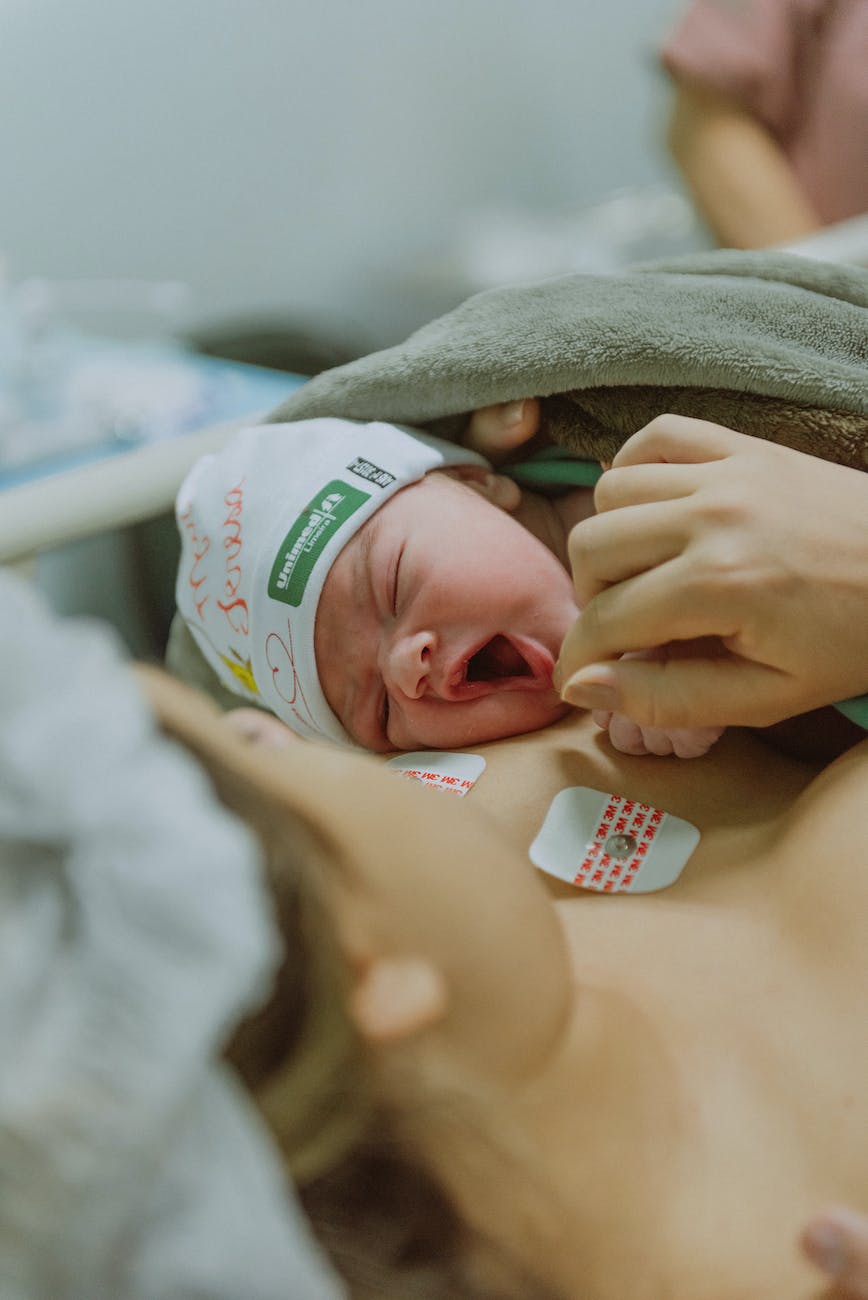 cute newborn baby on mother body after labor