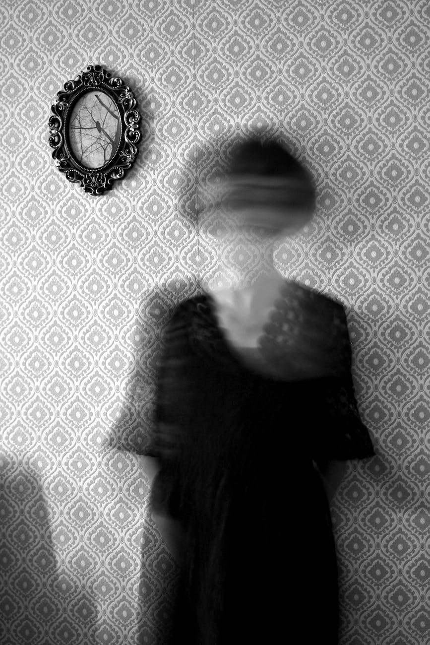 blurred woman on the background of a wall covered with wallpaper