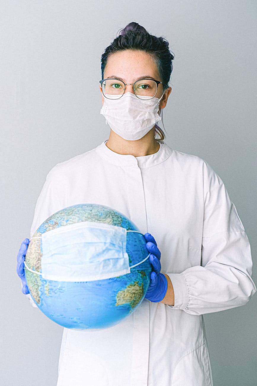 The World Can No Longer Afford Stupid People photo of person wearing protective wear while holding globe