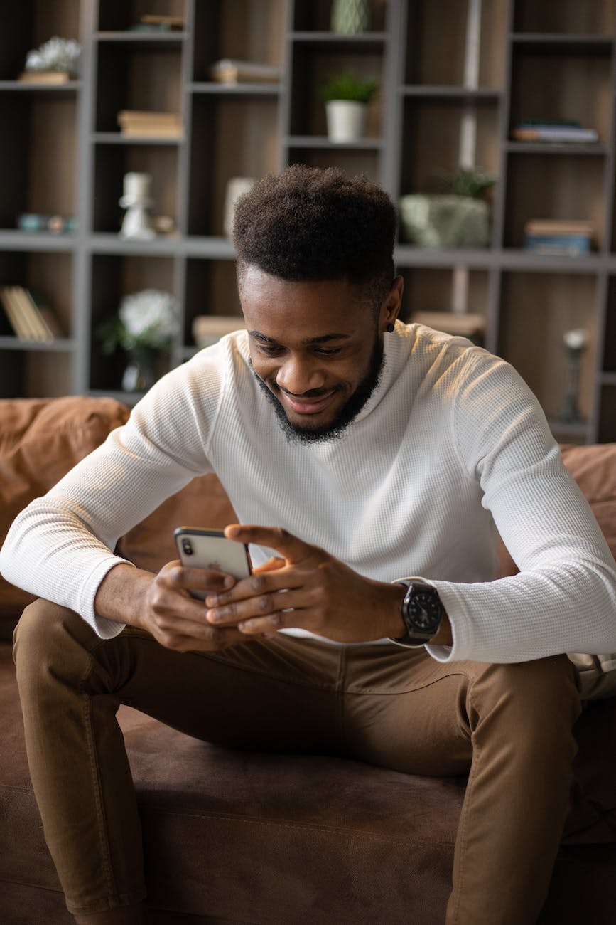 positive black man using smartphone while sitting on sofa - Connectivity Is Crucial To Our Future Security