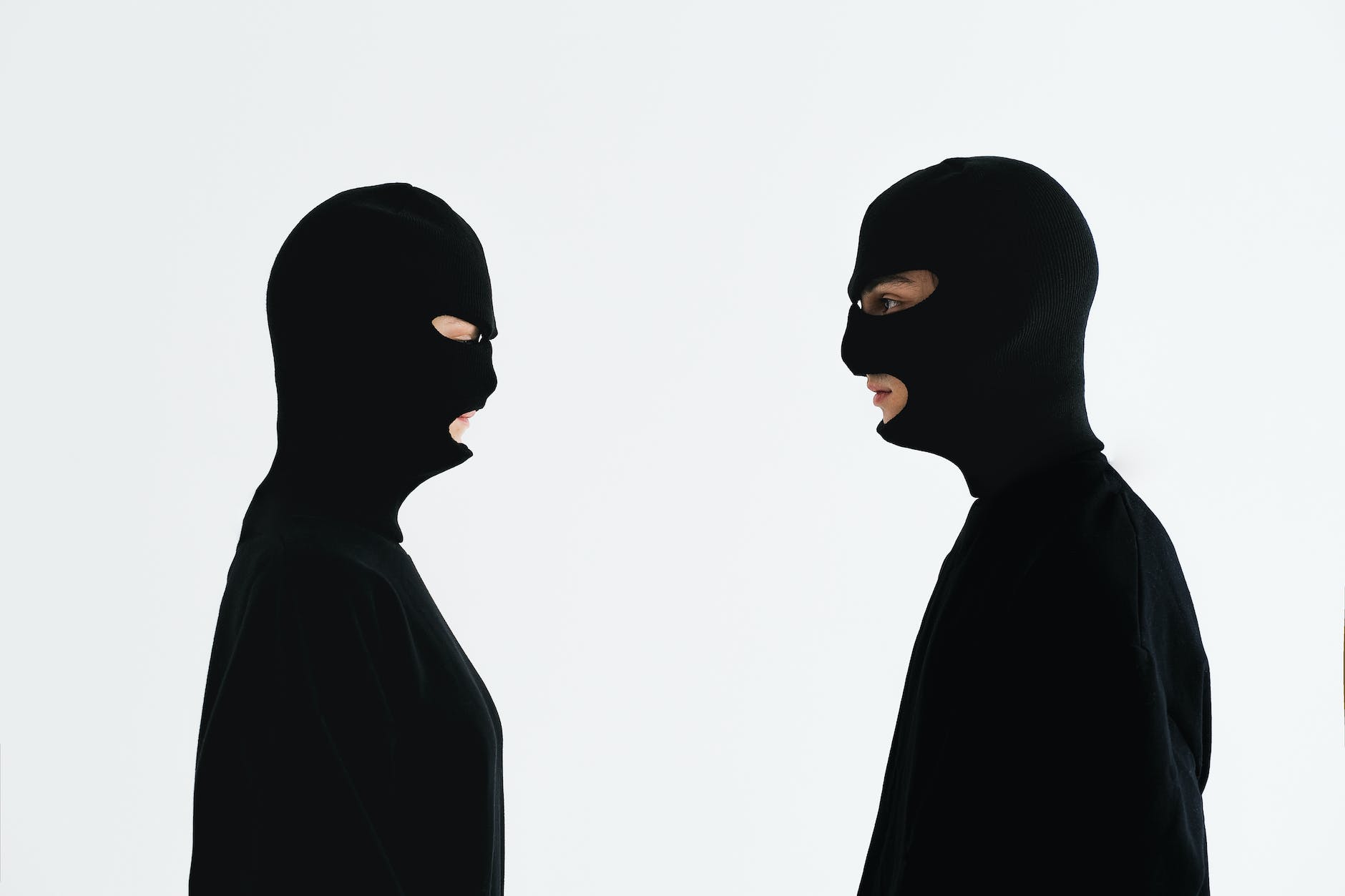 The rise of cybercrime: The widening gap between rich and poor - close up shot of two people wearing robber mask