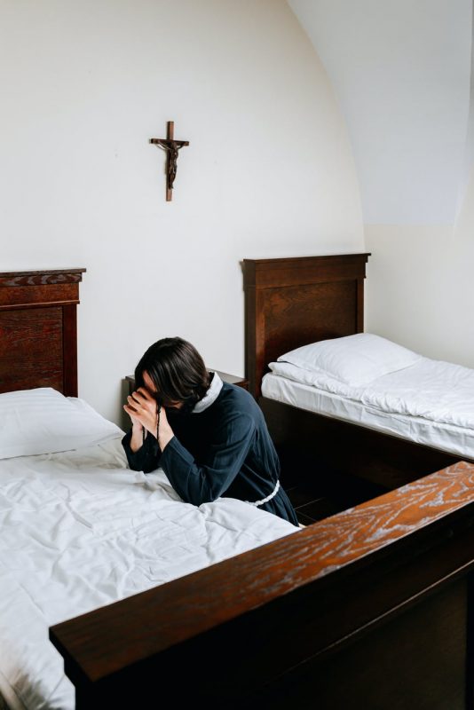 George Pell is dead - man praying beside a bed